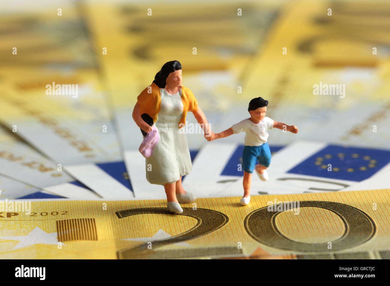 Prestaciones por hijo y subsidio de madre en miniatura con el Kid sobre billetes en euros Foto de stock