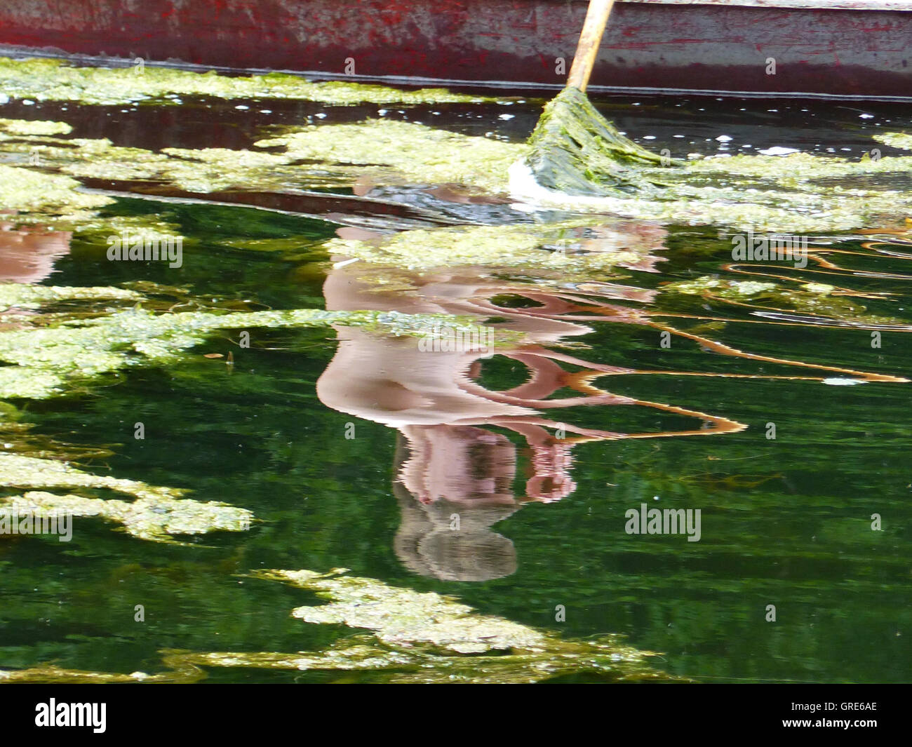 Distorsión de la imagen reflejada en el agua por el movimiento de las ondas Foto de stock