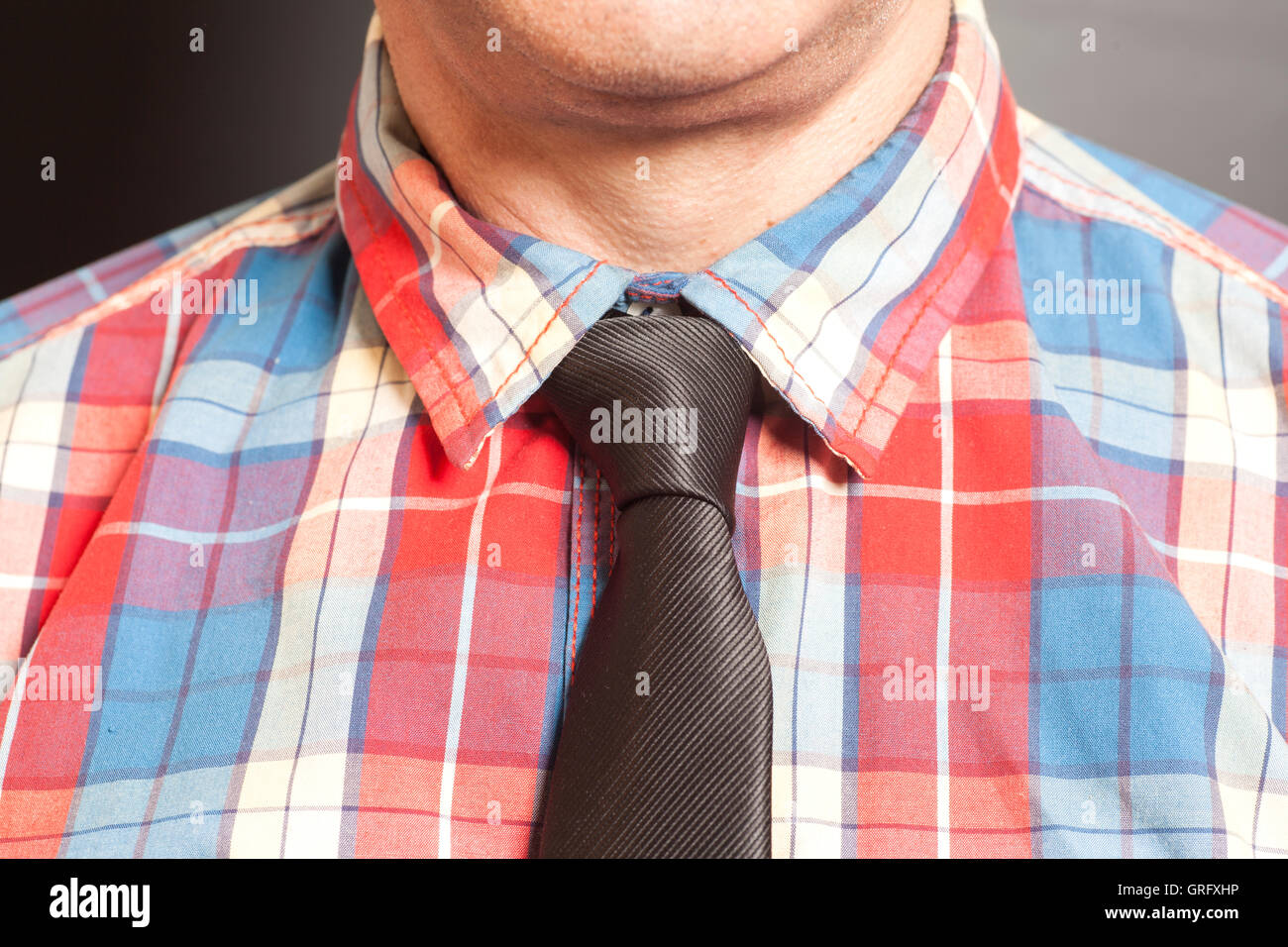 El hombre a cuadros con corbata negra sobre fondo gris Fotografía de stock - Alamy