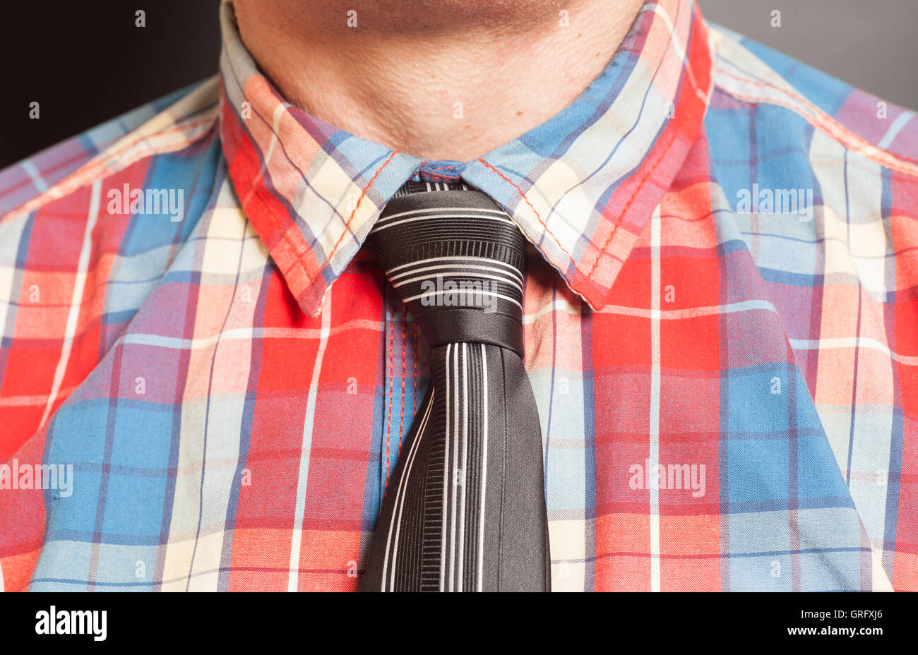 El hombre viste camisa a cuadros con corbata negra sobre fondo gris  Fotografía de stock - Alamy