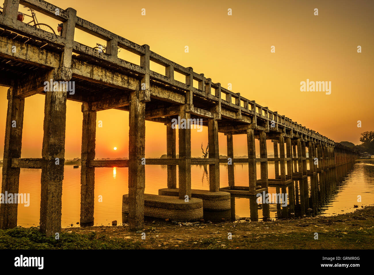 Puesta de sol sobre el Puente U Bein histórica de madera cerca de Mandalay, en Myanmar. La larga exposición. Foto de stock