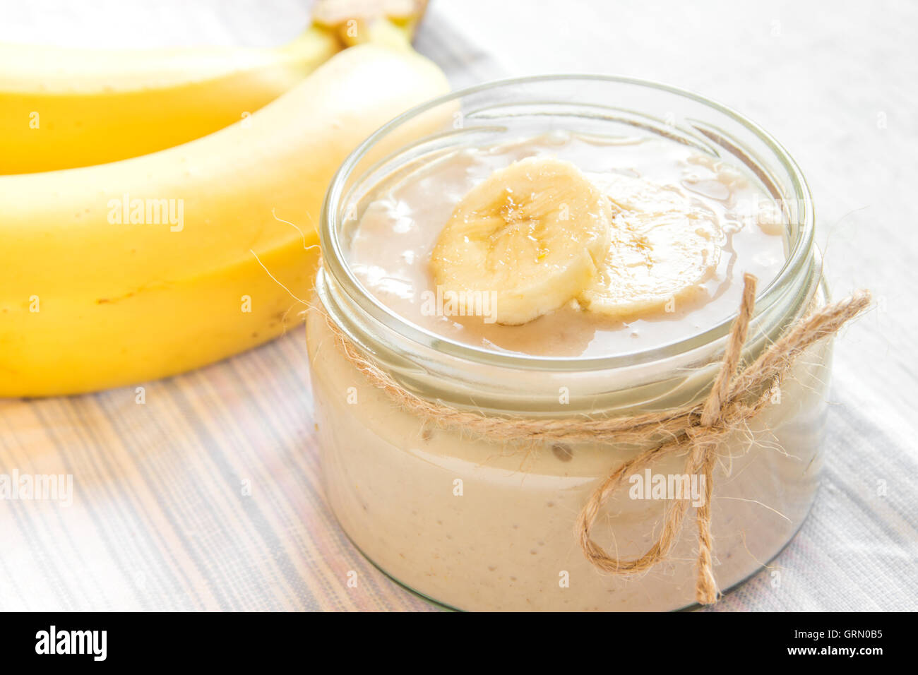 Mousse de plátano (pudín) para postre vegetariano saludable sobre fondo blanco. Foto de stock