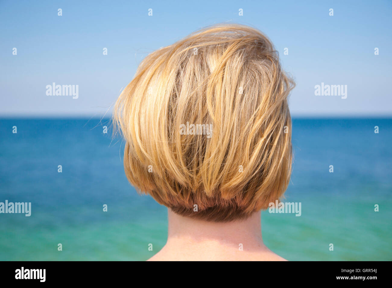 Mujer rubia contemplando el mar Foto de stock