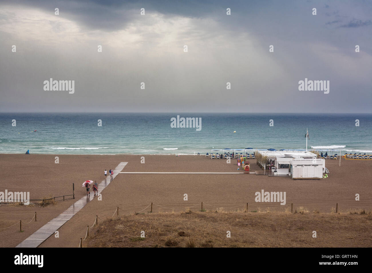Tormenta de lluvia a lo largo de playa en temporada de verano. La gente regresó a casa Foto de stock