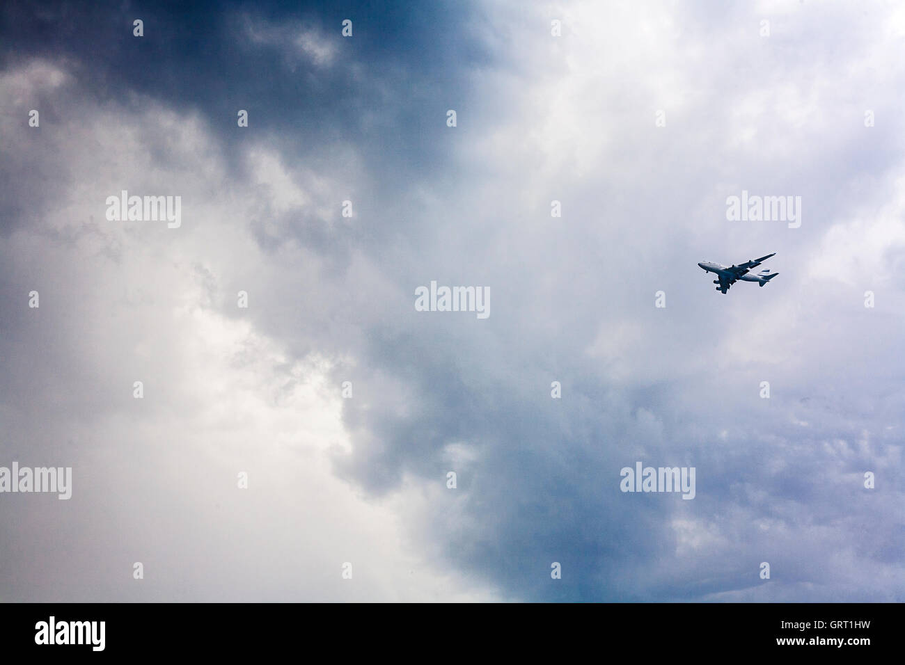 Pasajero avión aproximándose contra un cielo tormentoso Foto de stock