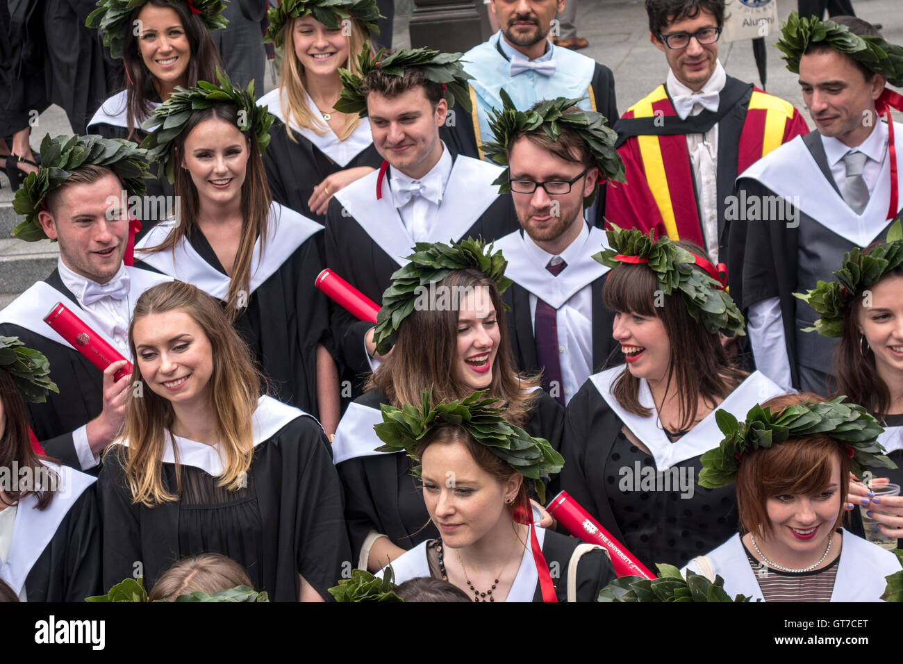 Día de Graduación en la Universidad de Edimburgo. Feliz graduandos luciendo coronas de laureles. Foto de stock