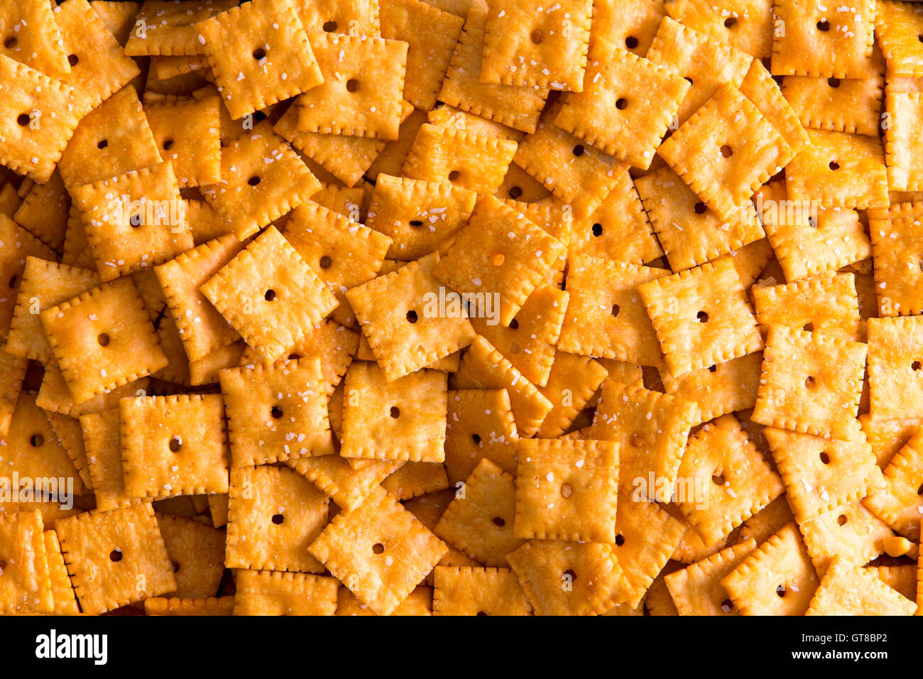 Textura de fondo de square, galletas de queso con agujeros centrales dispuestos en una capa de cerca de fotograma completo vistos desde arriba Foto de stock