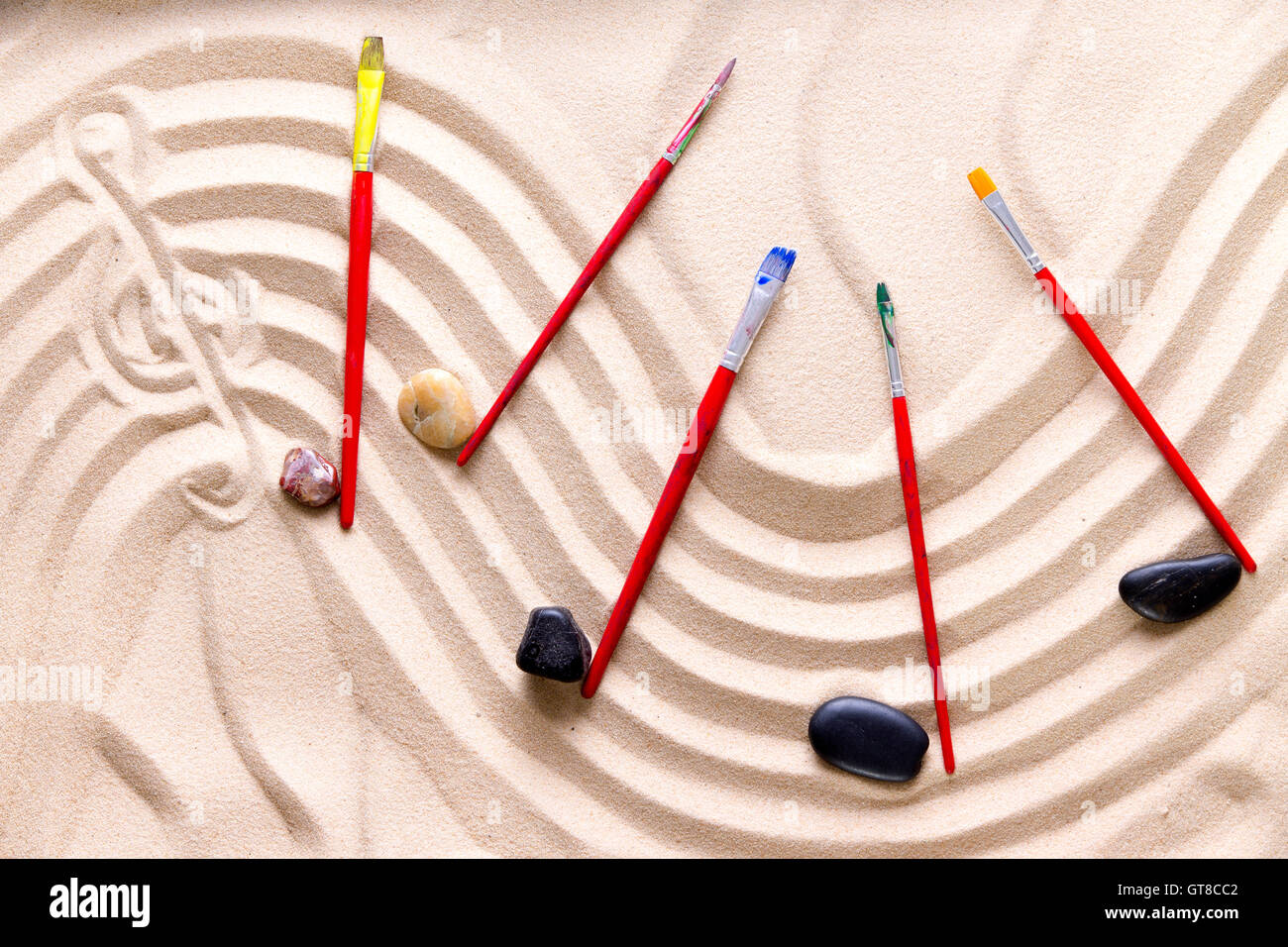 La armonía y la música en la playa con una artística imagen conceptual de una puntuación ondulado dibujado en la arena dorada con un clef agudo Foto de stock