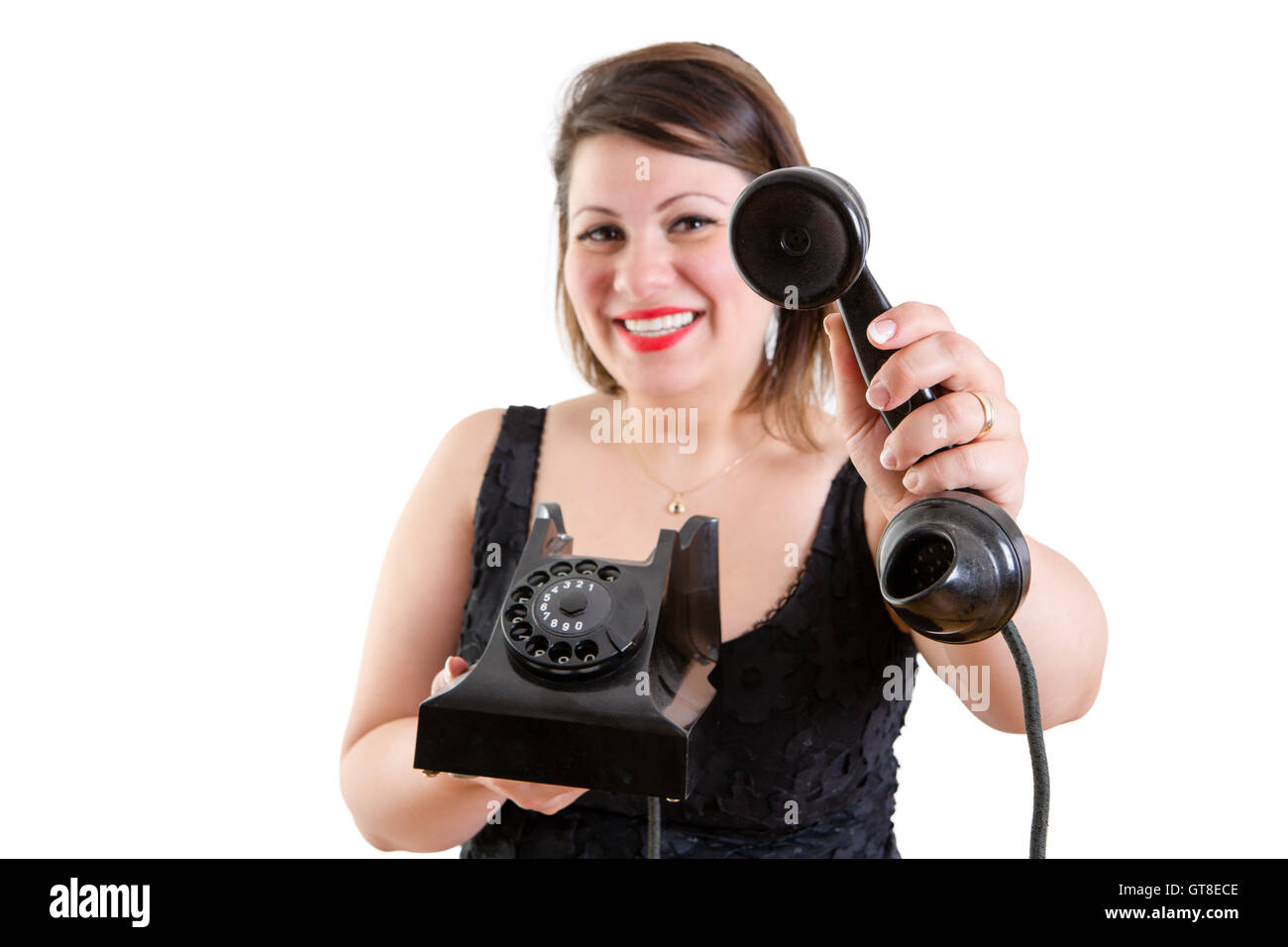Sonriente, amable mujer atractiva la celebración de un antiguo teléfono de línea terrestre instrumento -una llamada para usted señor - Foto de stock