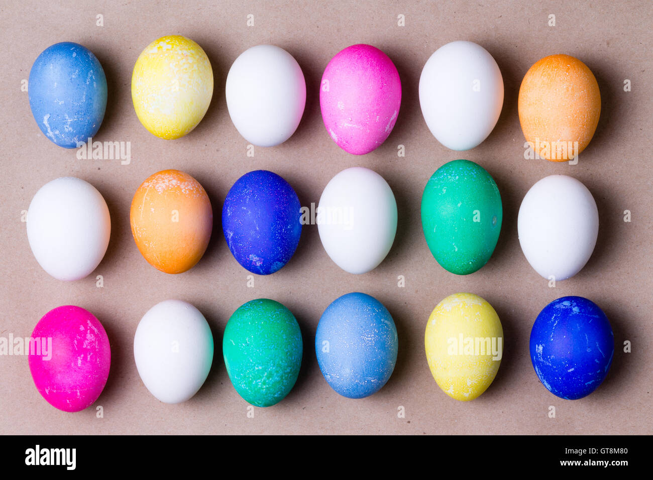 Disposición ordenada de coloridos huevos de Pascua teñidos en tres filas en un fondo de vacaciones festivas para celebrar una Pascua tradicional Foto de stock