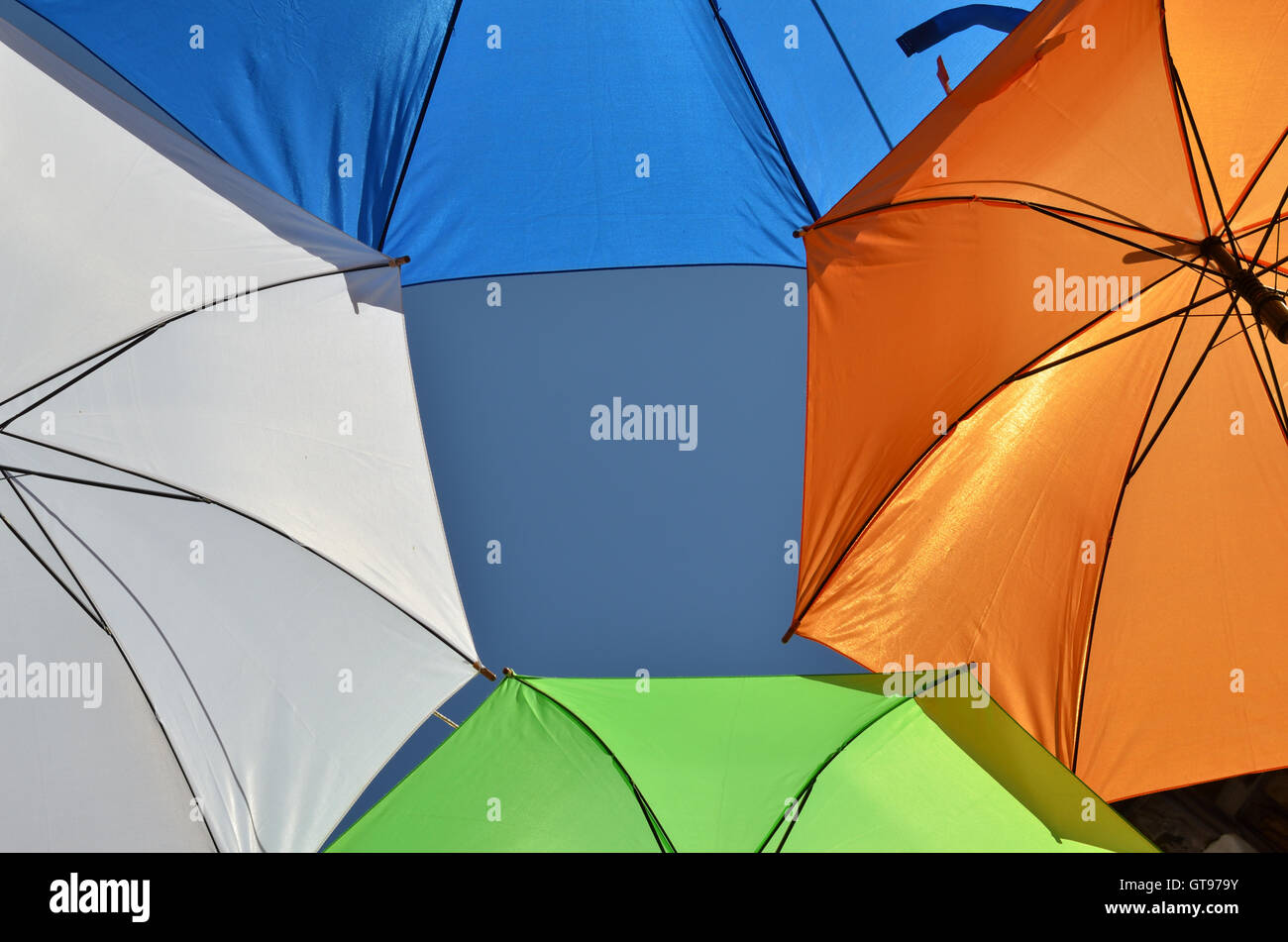 Las partes de color blanco, verde, azul y naranja paraguas con una parte de cielo para copiar texto de stock - Alamy