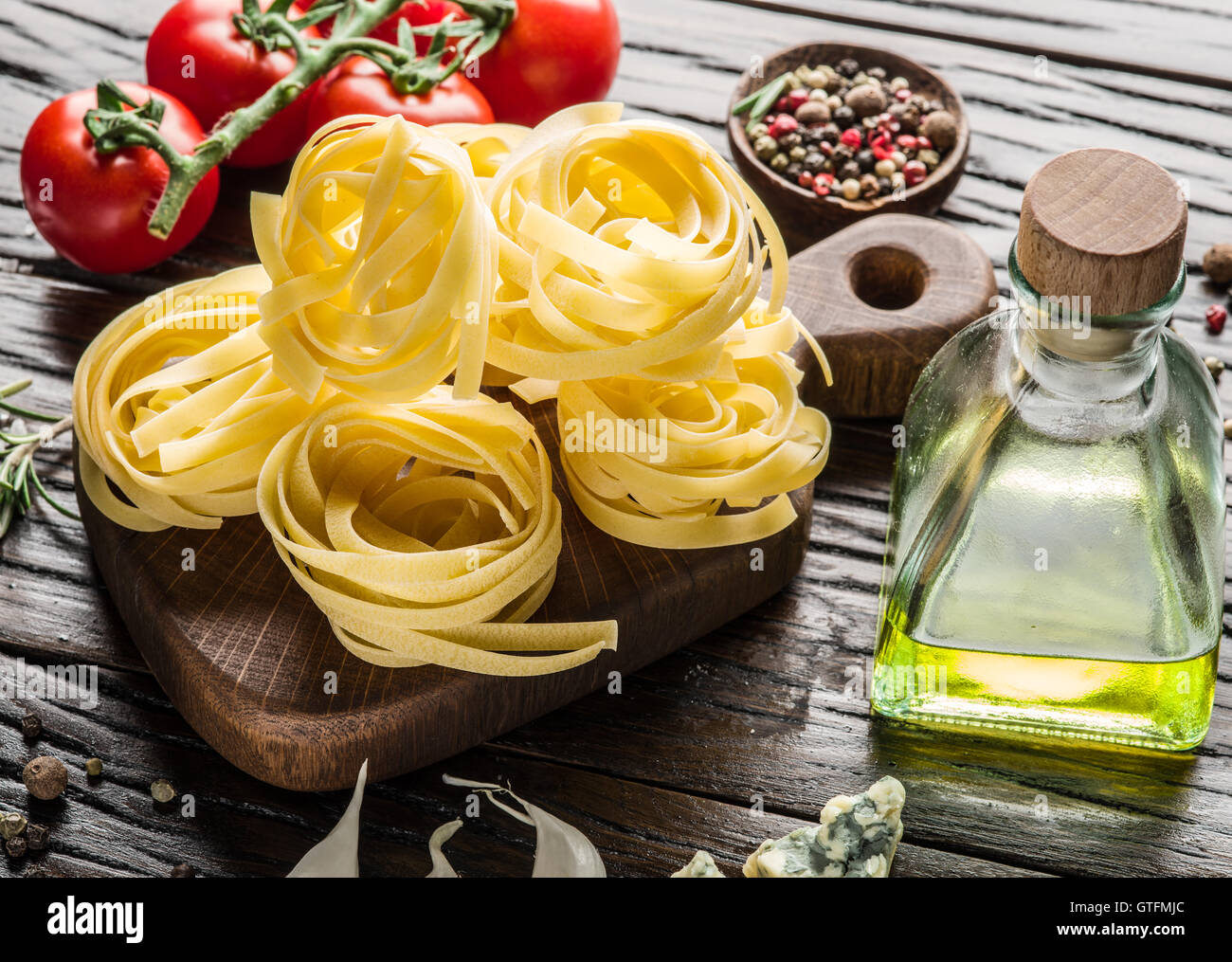 Pasta ingredientes. Tomates cereza y spaghetti pasta sobre la mesa de madera. Foto de stock