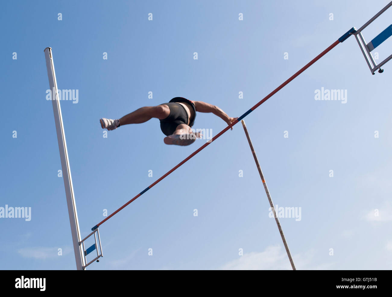 Atleta Masculino salta en la acción de salto con garrocha la