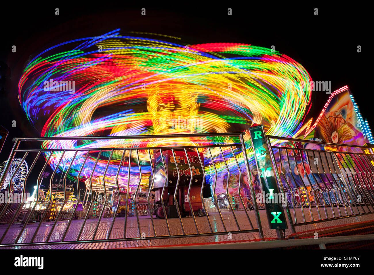 Remolinos de paseo por el carnaval en la noche con las luces y con efecto de desenfoque de movimiento Foto de stock