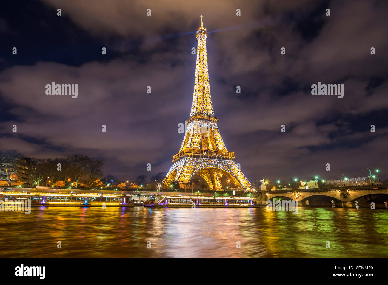 París, Francia - 14 de febrero de 2016: La Torre Eiffel luces doradas, en la noche, que se refleja en las aguas del río Sena. Foto de stock