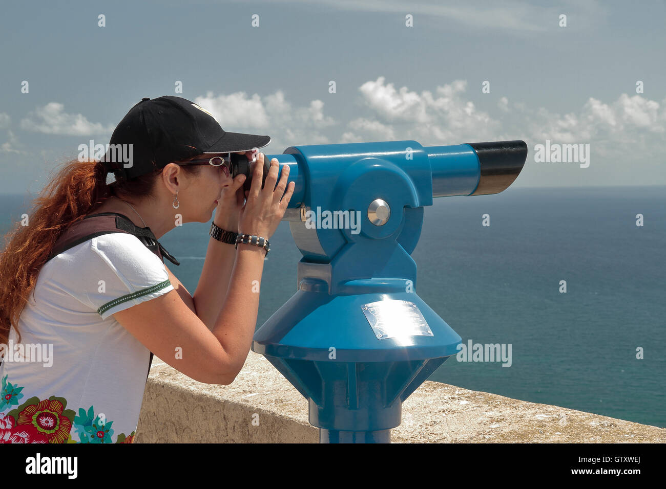 Mujer usando un telescopio panorámico con vistas al mar Fotografía de stock  - Alamy