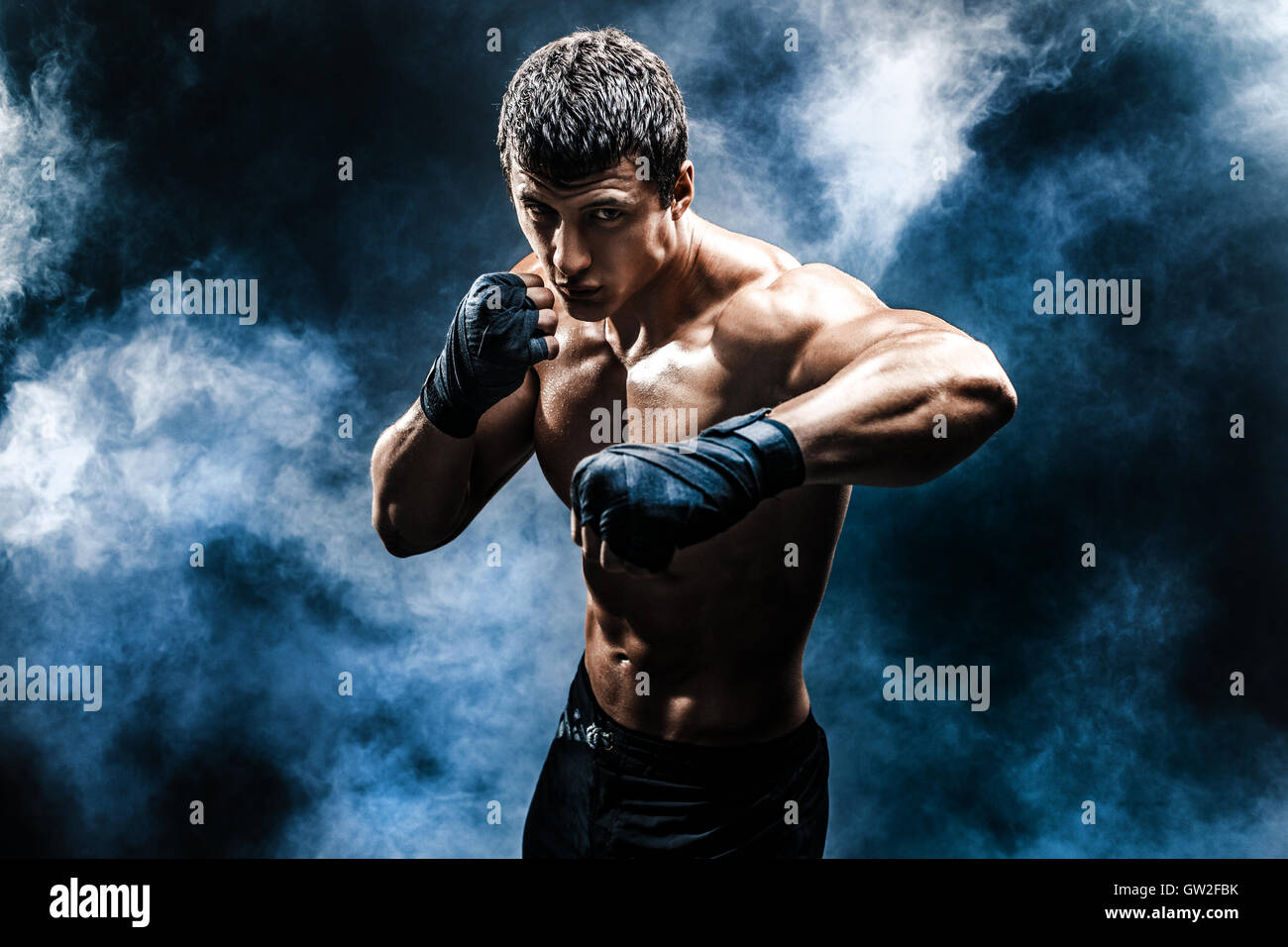 Musculoso kick-box o muay thai fighter puñetazos en el humo Fotografía de  stock - Alamy