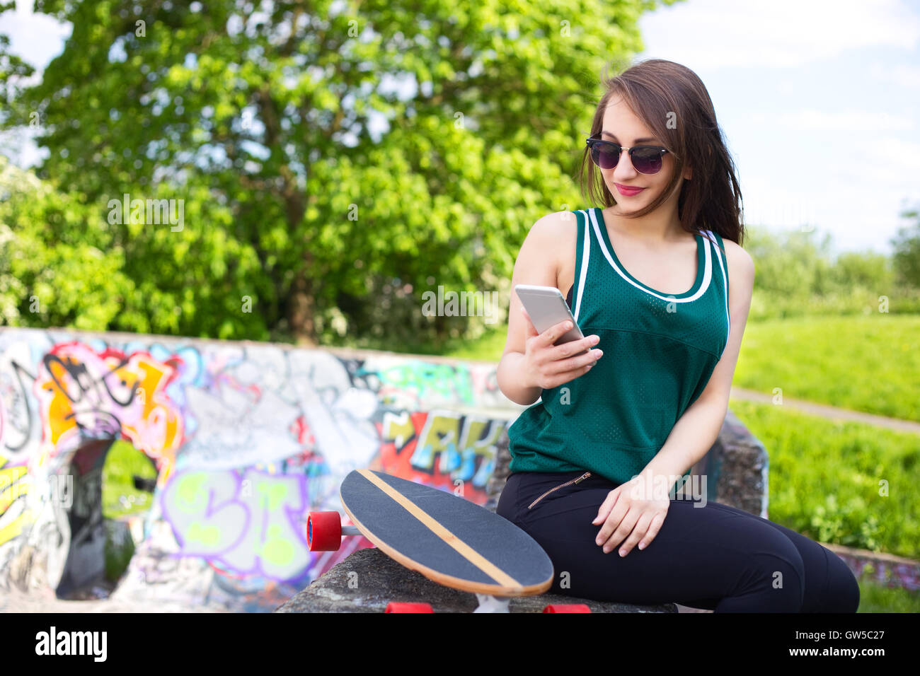 Joven skater de revisar sus mensajes de texto Foto de stock