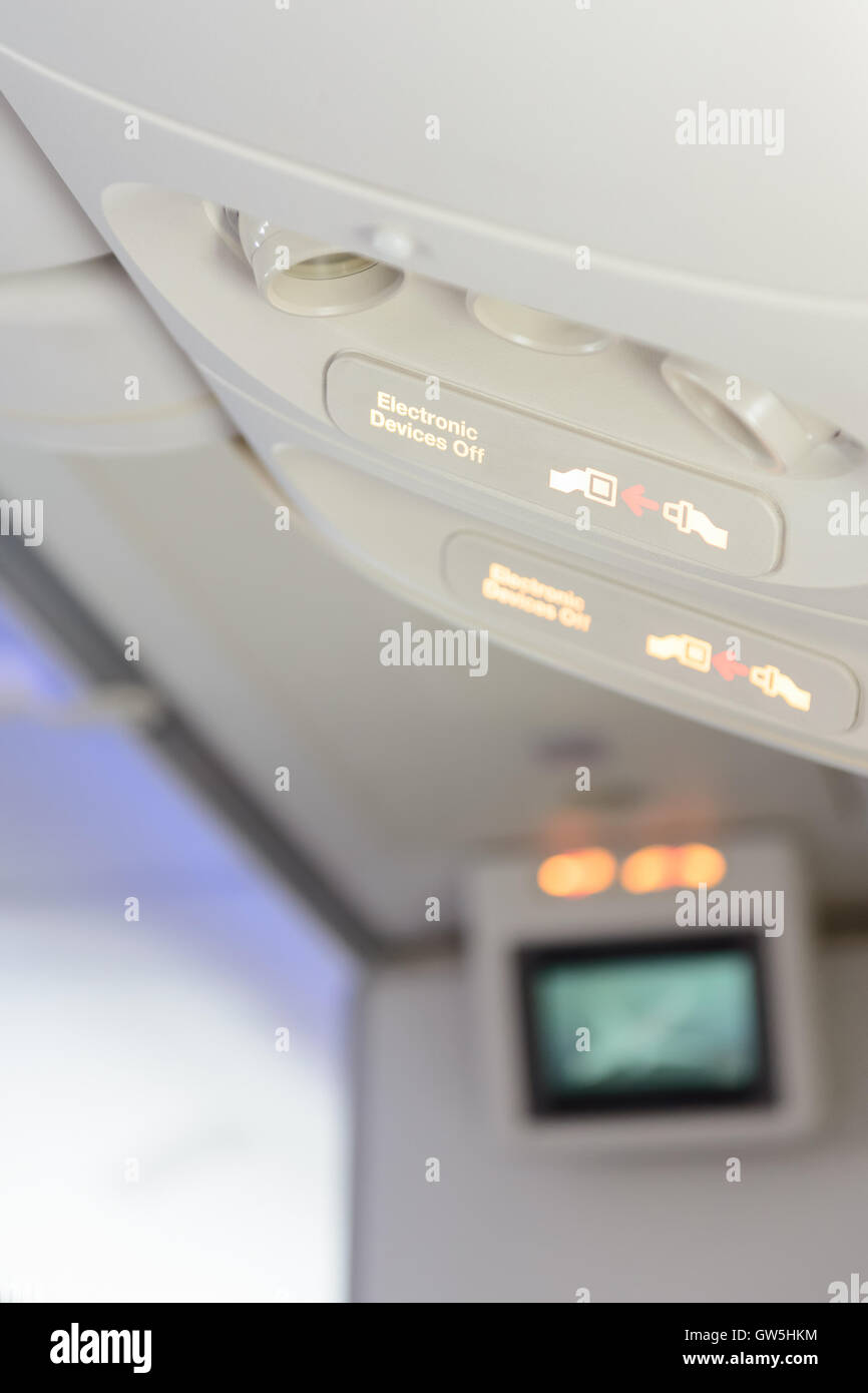 Dispositivos electrónicos y señal de abrochar los cinturones de seguridad dentro del avión. Foto de stock