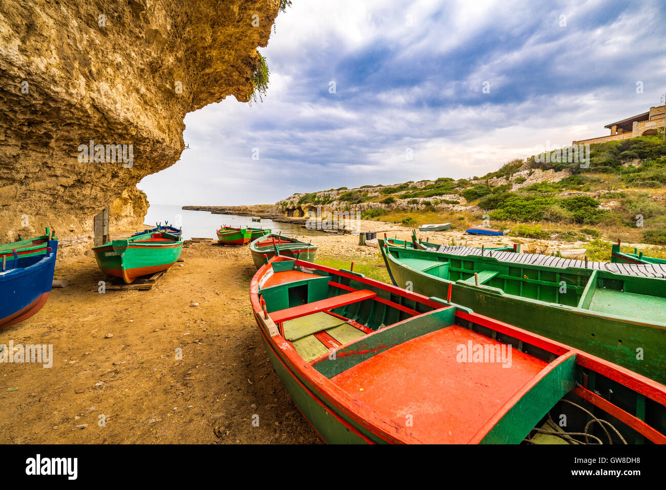 Embarcaciones de remo de color encallado en una bahía de la costa de Apulia, en el sur de Italia Foto de stock