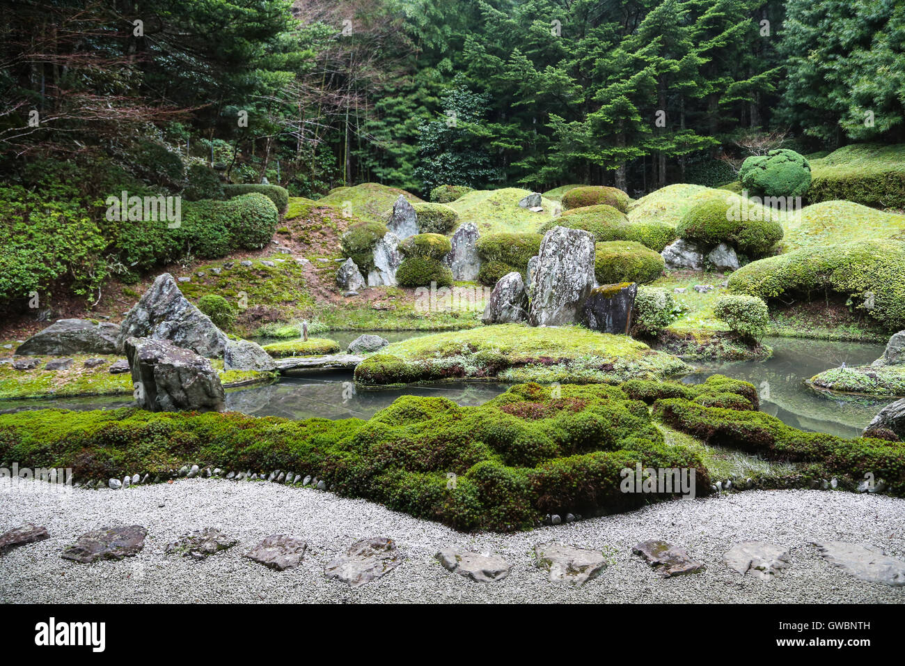 Tranquilo jardín zen japonés con un estanque, piedras, grava y Moss Foto de stock