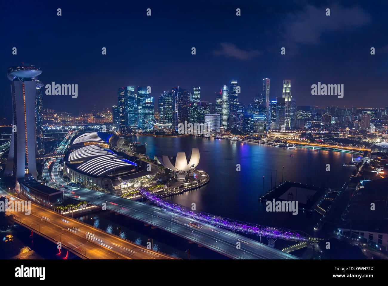 Vista aérea del perfil de Singapur y el centro de la ciudad por la noche. Reflejo de las luces de los rascacielos en marina bay Foto de stock
