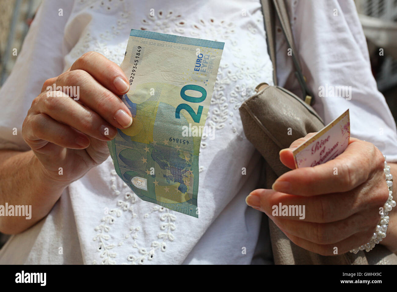 Señoras una mano sujetando un veinte euros € Foto de stock