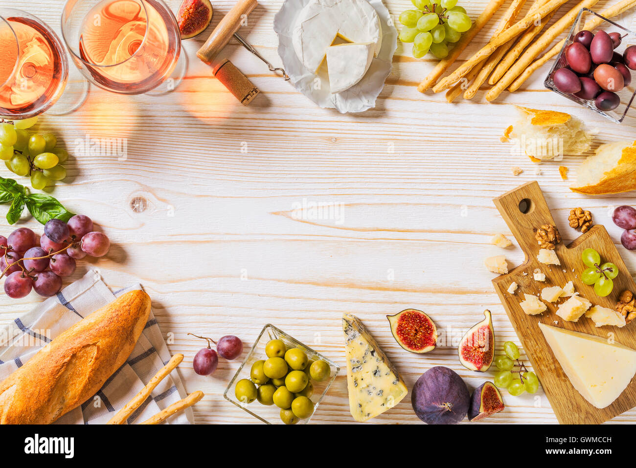 Los diferentes tipos de quesos, vino, baguettes y frutas en blanco Foto de stock