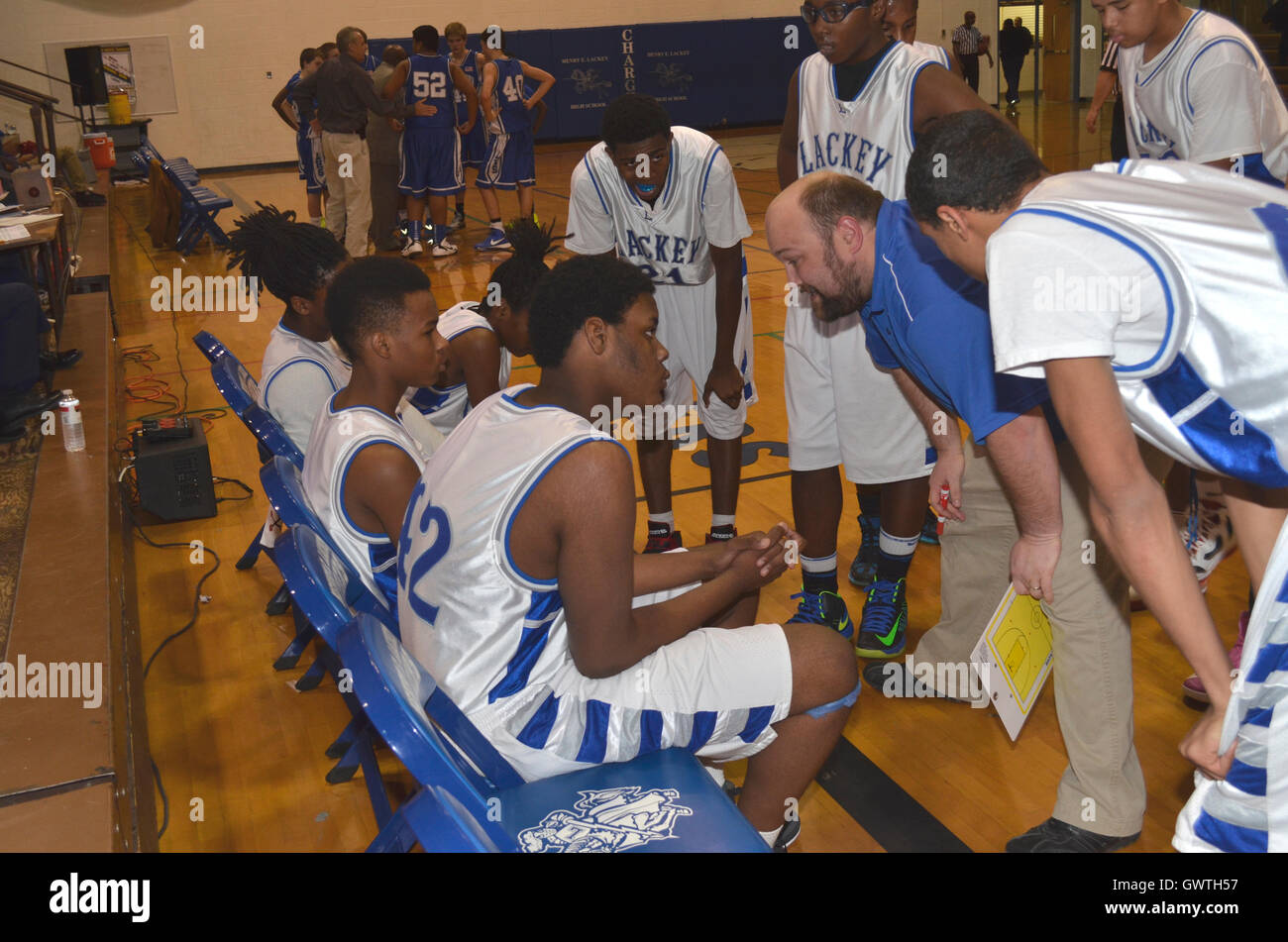 Entrenador analiza la estrategia con un juego de baloncesto de la escuela secundaria Foto de stock