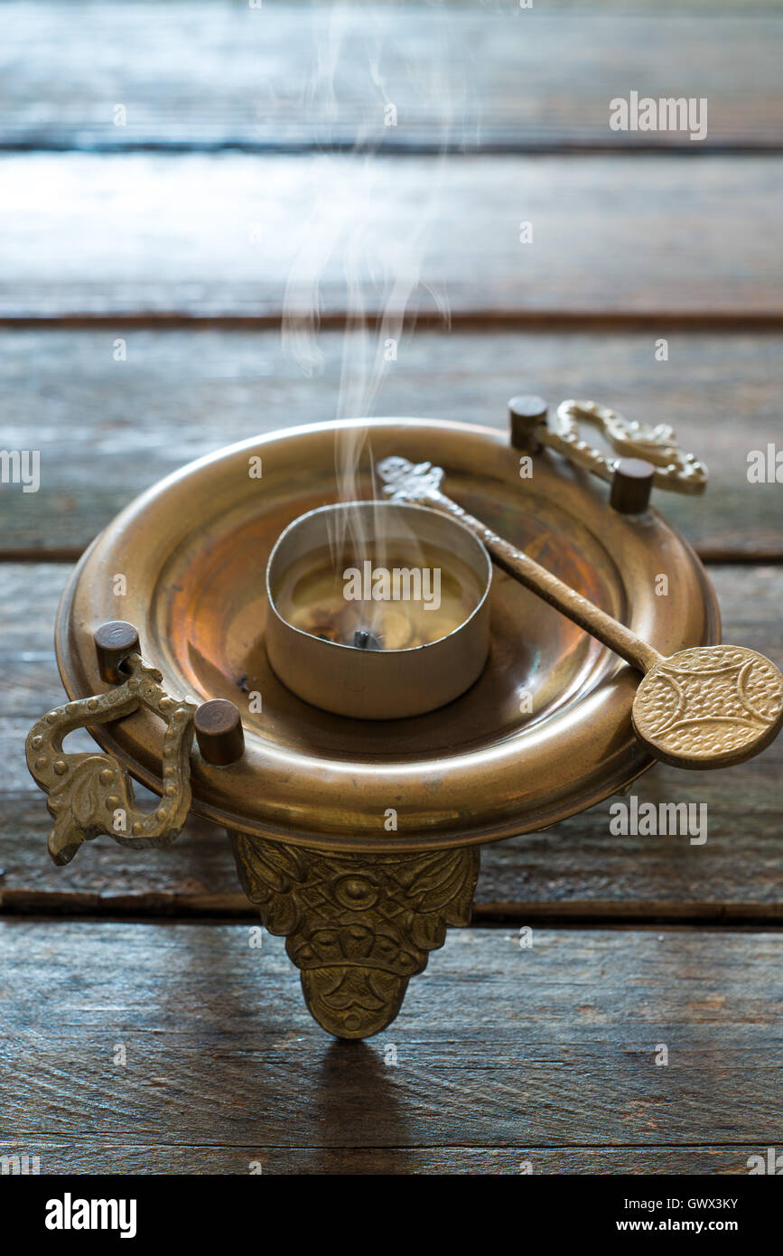 Brasero de bronce de cocción sobre mesa de madera Foto de stock