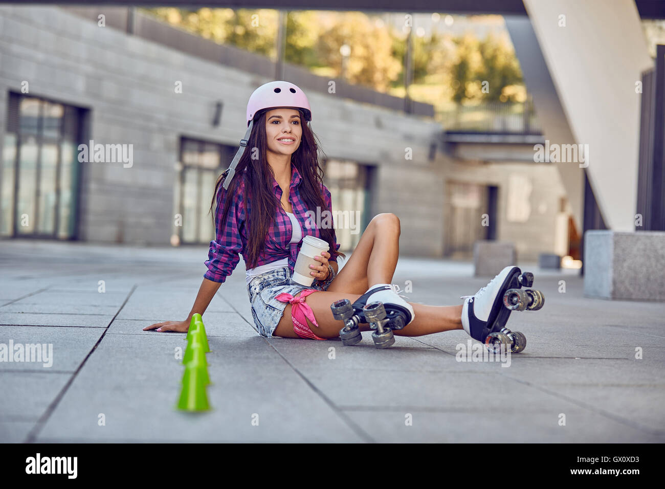 Mujer joven tener un descanso después de patinar y bebiendo café Foto de stock