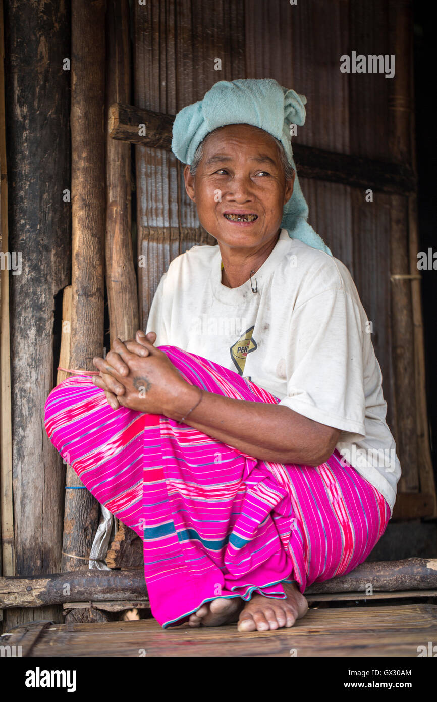 Mujer de la tribu de la colina de la blanca Karen (Kayin) gente que se sienta con vestido tradicional, en la puerta de su casa, la frontera entre Tailandia y Myanmar, el sudeste de Asia, Asia Foto de stock