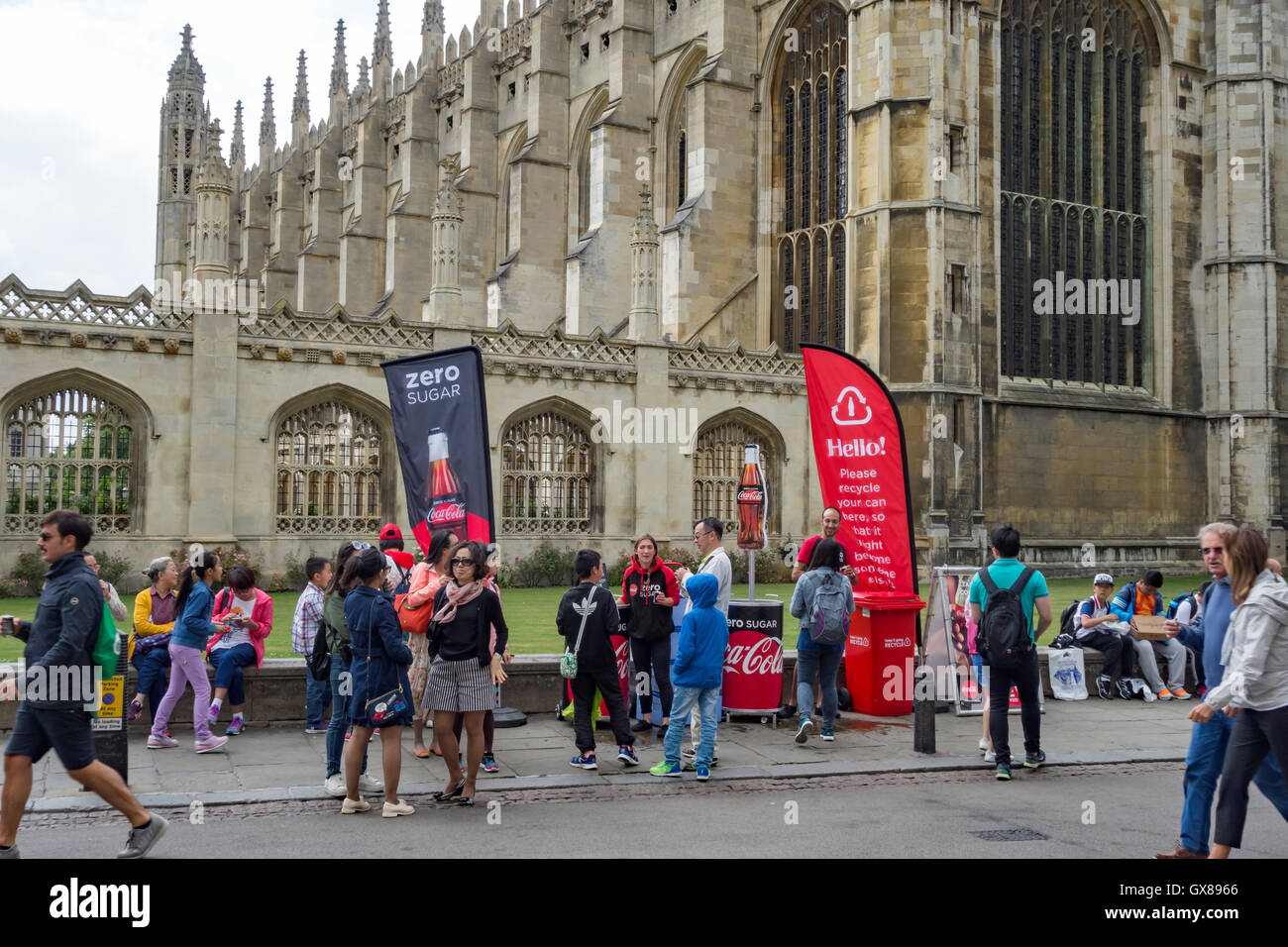Las personas que promueven la venta de azúcar cero Coca Cola en Reyes desfilan delante de Kings College, con la capilla de los Reyes, detrás de la ciudad de Cambridge Foto de stock