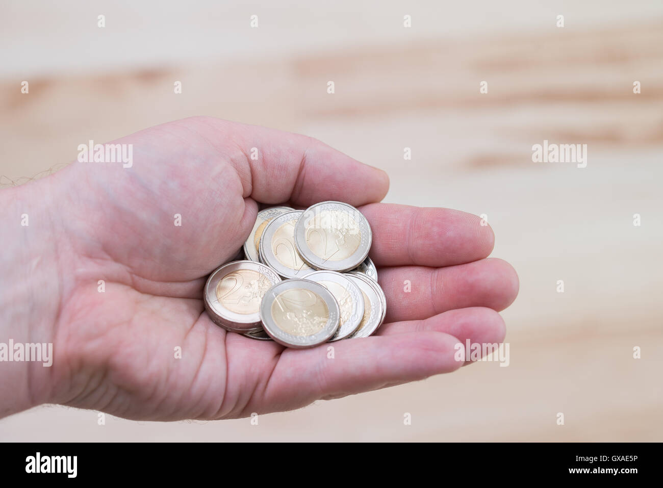 Dos monedas de euro en la mano Foto de stock