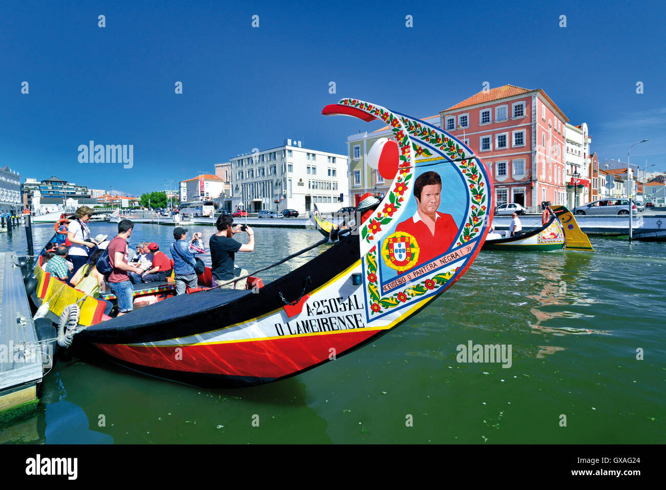 Portugal: turistas tomando fotos de barco pasando sus coloridos Moliceiro barco en Aveiro Foto de stock