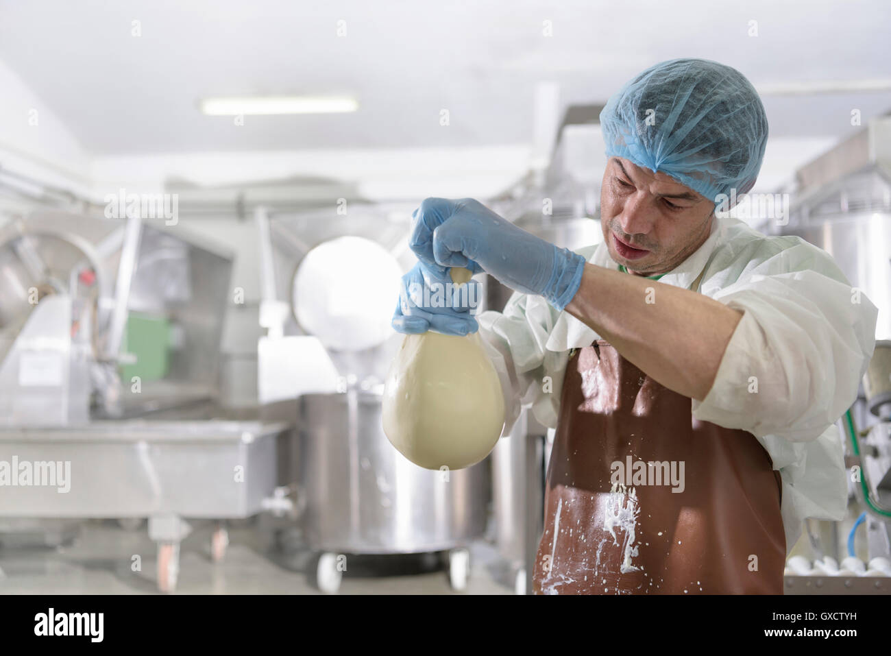 Trabajador haciendo a mano en la fábrica de queso mozzarella bola Foto de stock