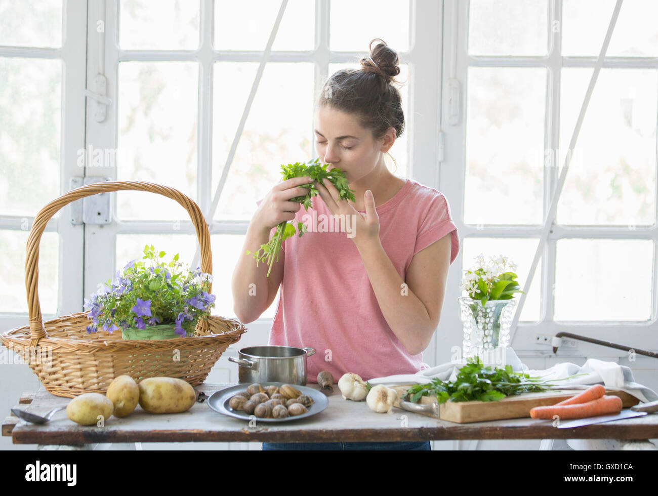 Mujer joven olorosas hierbas silvestres en cocina, Vogogna,Verbania, Piemonte, Italia Foto de stock