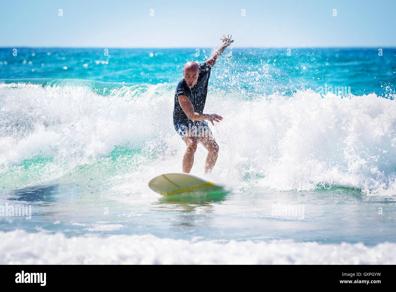 Surfer disfrutando de las olas altas en un brillante día soleado, un estilo de vida activo, extreme deportes acuáticos, actividades de verano Foto de stock