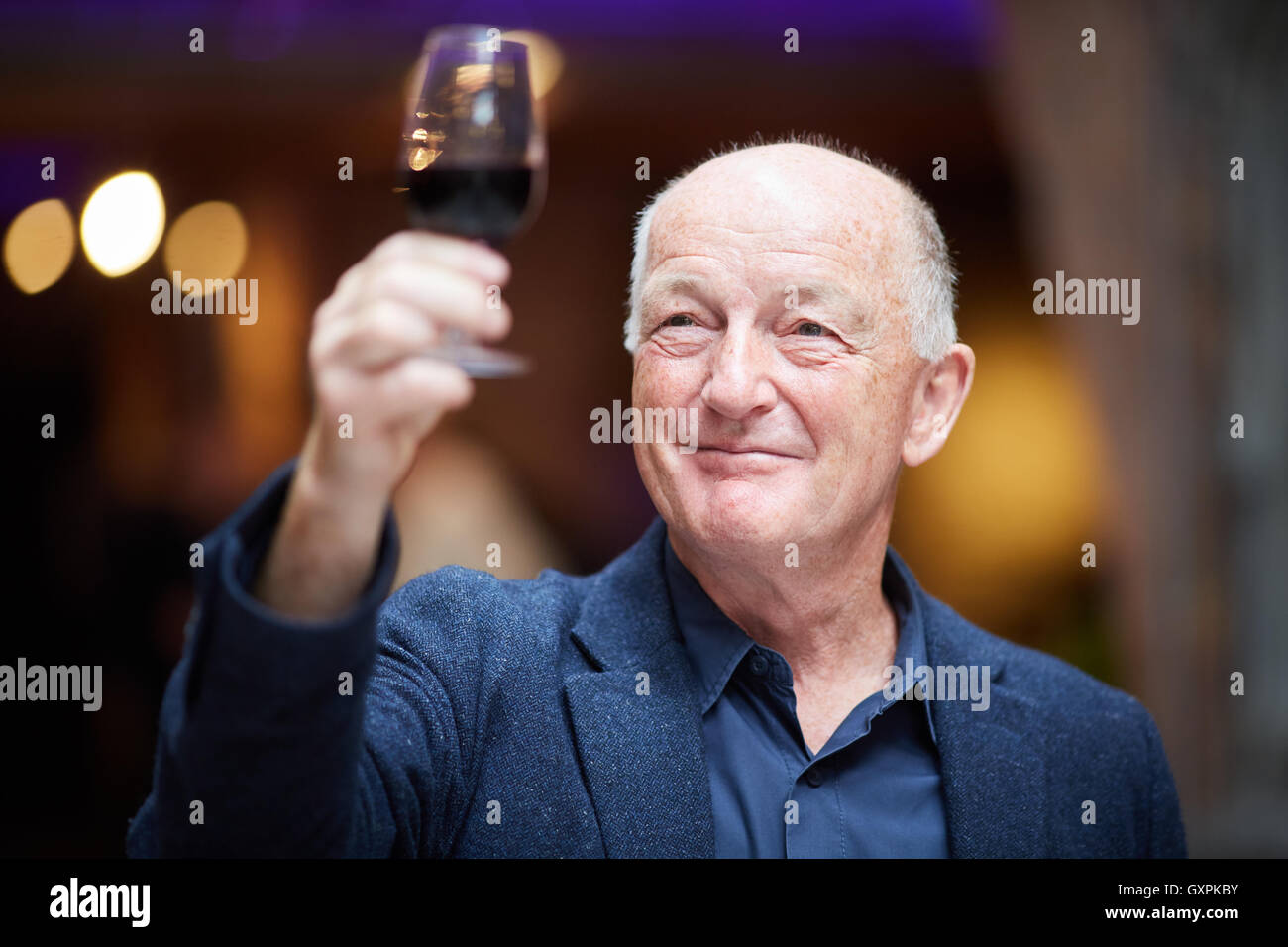 Bolton Festival de Comida y bebida con un vaso de vino tinto experto Oz Clarke, presentador de televisión y locutor vino tinto holding de vidrio mirando Foto de stock
