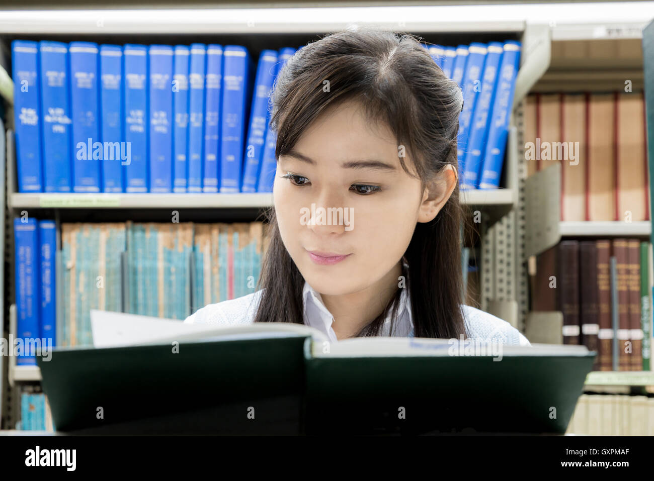Estudiante de la High School secundaria de Asia leyendo en la biblioteca de la universidad. Uno asiático estudiante de la High School secundaria. Foto de stock