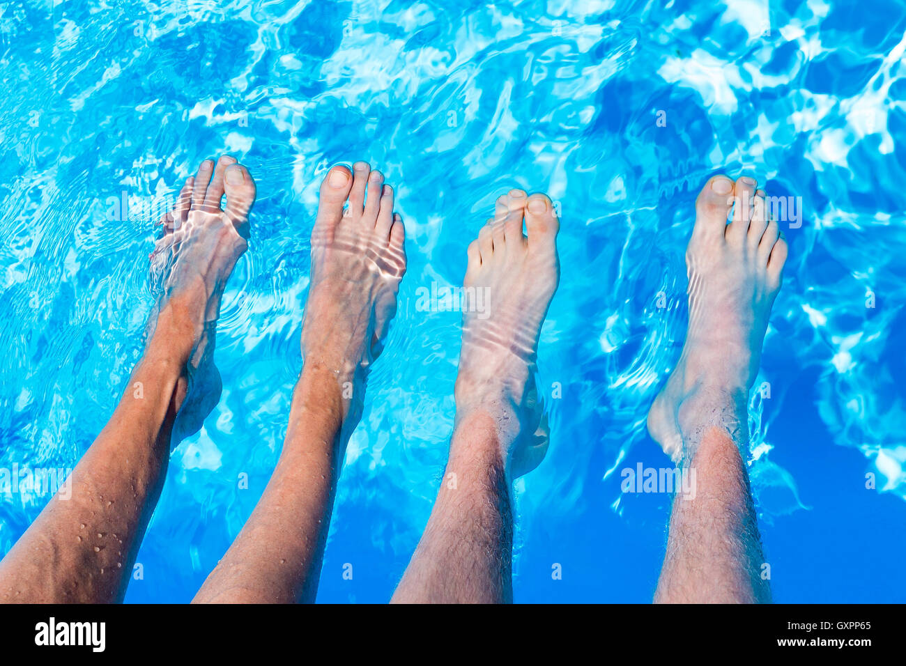 Cuatro patas adolescente desnudo con cuatro pies en el agua de la piscina  azul Fotografía de stock - Alamy