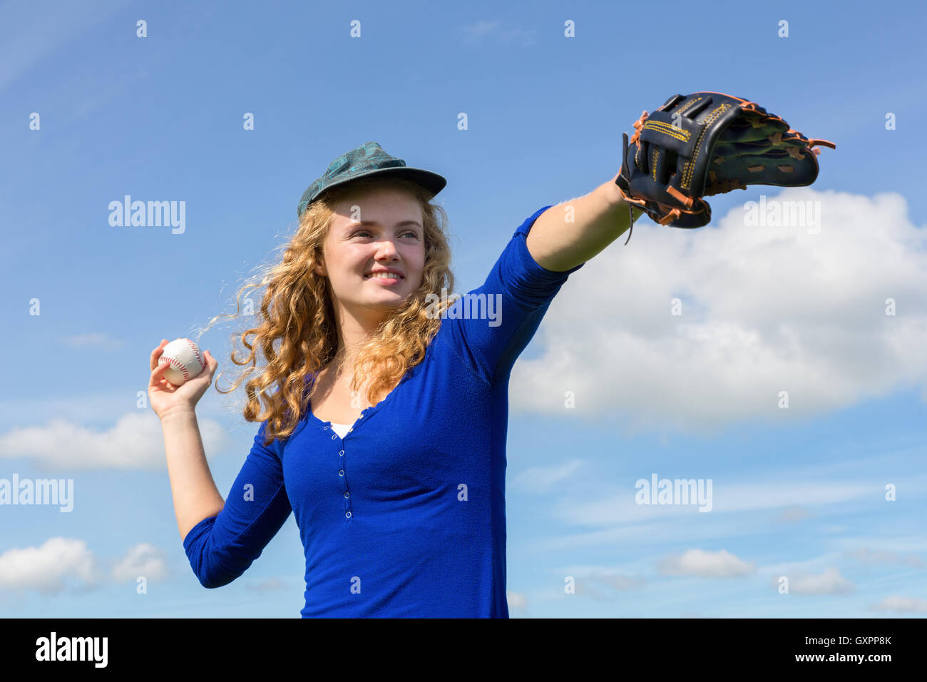 Joven mujer caucásica jugando béisbol con pernos de guante y bola Foto de stock