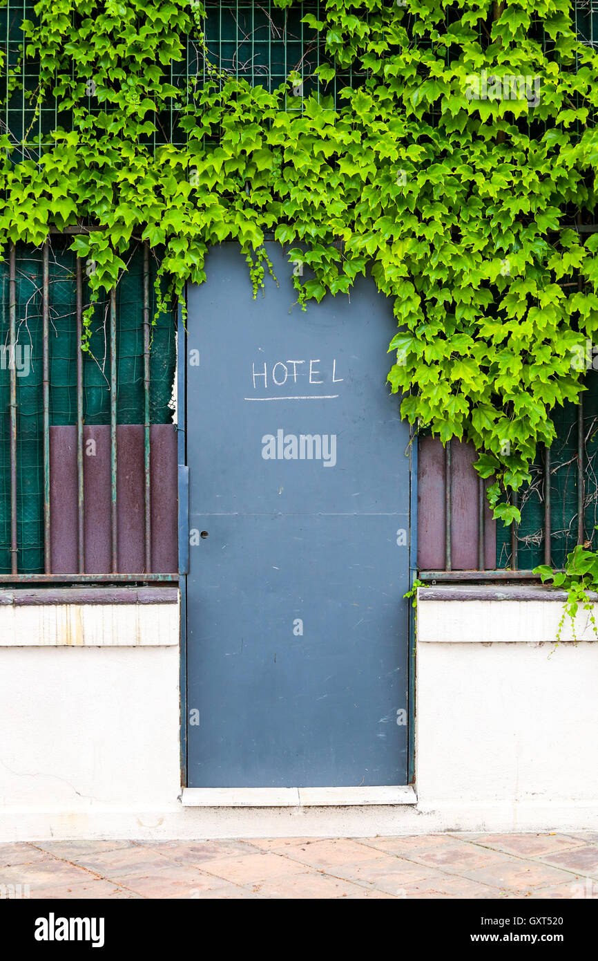 Hotel Puerta de entrada con cartel en una valla con follaje verde Foto de stock