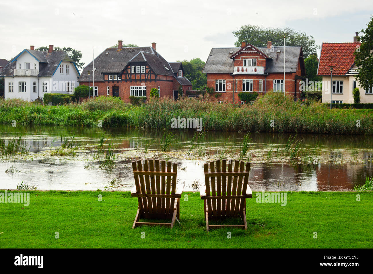 Dos sillones de madera hacia el río Ribe, Dinamarca Foto de stock