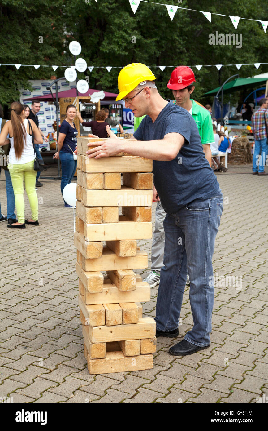 Contratista hombre jugando al aire libre. Grande, Grande, Jenga gigante