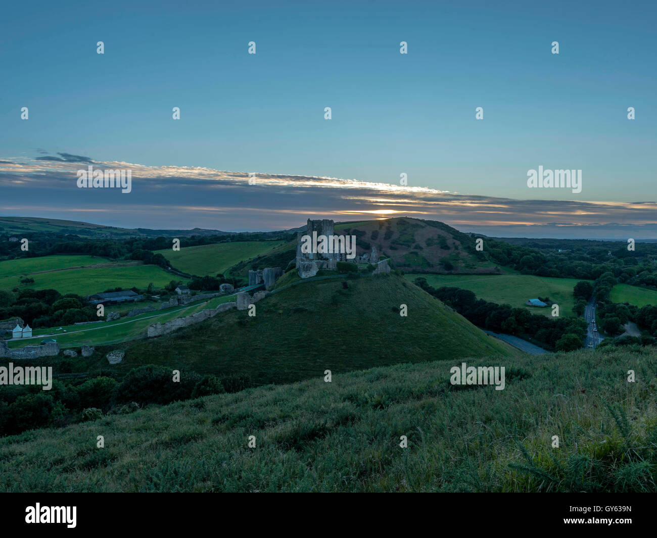 Paisaje representando a finales del verano el atardecer en el castillo Corfe, en Dorset, Reino Unido Foto de stock