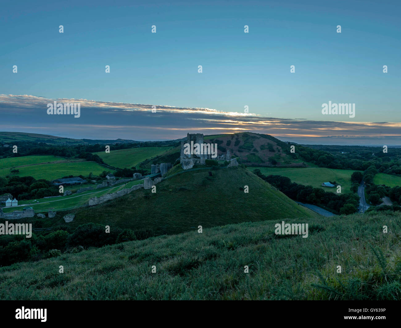 Paisaje representando a finales del verano el atardecer en el castillo Corfe, en Dorset, Reino Unido Foto de stock