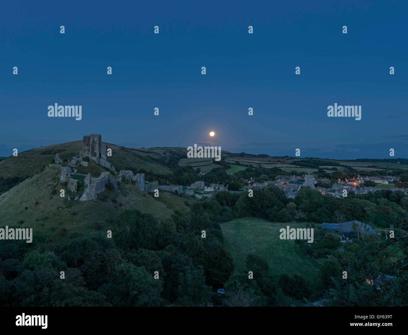 Paisaje representando a finales del verano Luna de la cosecha suba en el castillo Corfe, en Dorset, Reino Unido Foto de stock