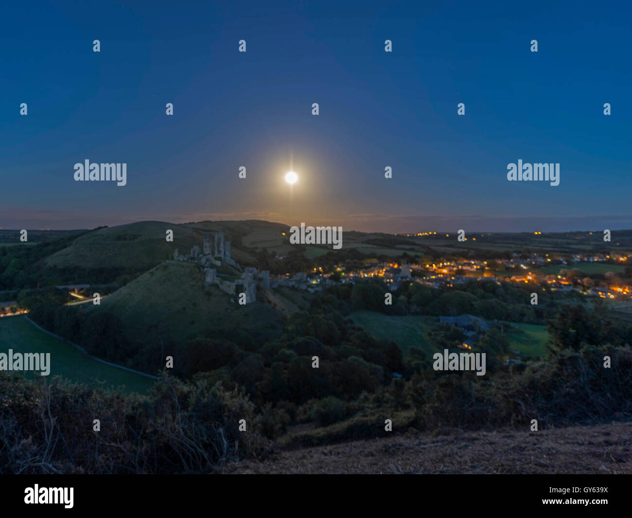 Paisaje representando a finales del verano Luna de la cosecha suba en el castillo Corfe, en Dorset, Reino Unido Foto de stock