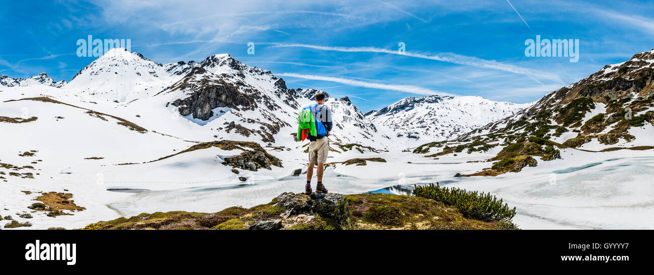 Caminante se sitúa delante de paisajes de montaña, la nieve se derrite, Rohrmoos-Untertal, Schladming Tauern, Schladming, Estiria, Austria Foto de stock